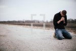 lightstock-60128-man-kneeling-in-prayer-in-the-middle-of-a-road--3.jpg