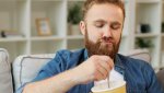 videoblocks-portrait-of-young-man-eating-ice-cream-while-sitting-on-sofa-in-the-living-room-clos.jpg